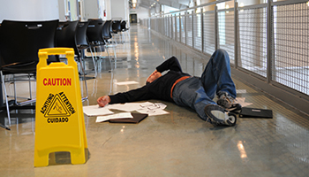 A man lying on the floor, indicating a slip and fall incident